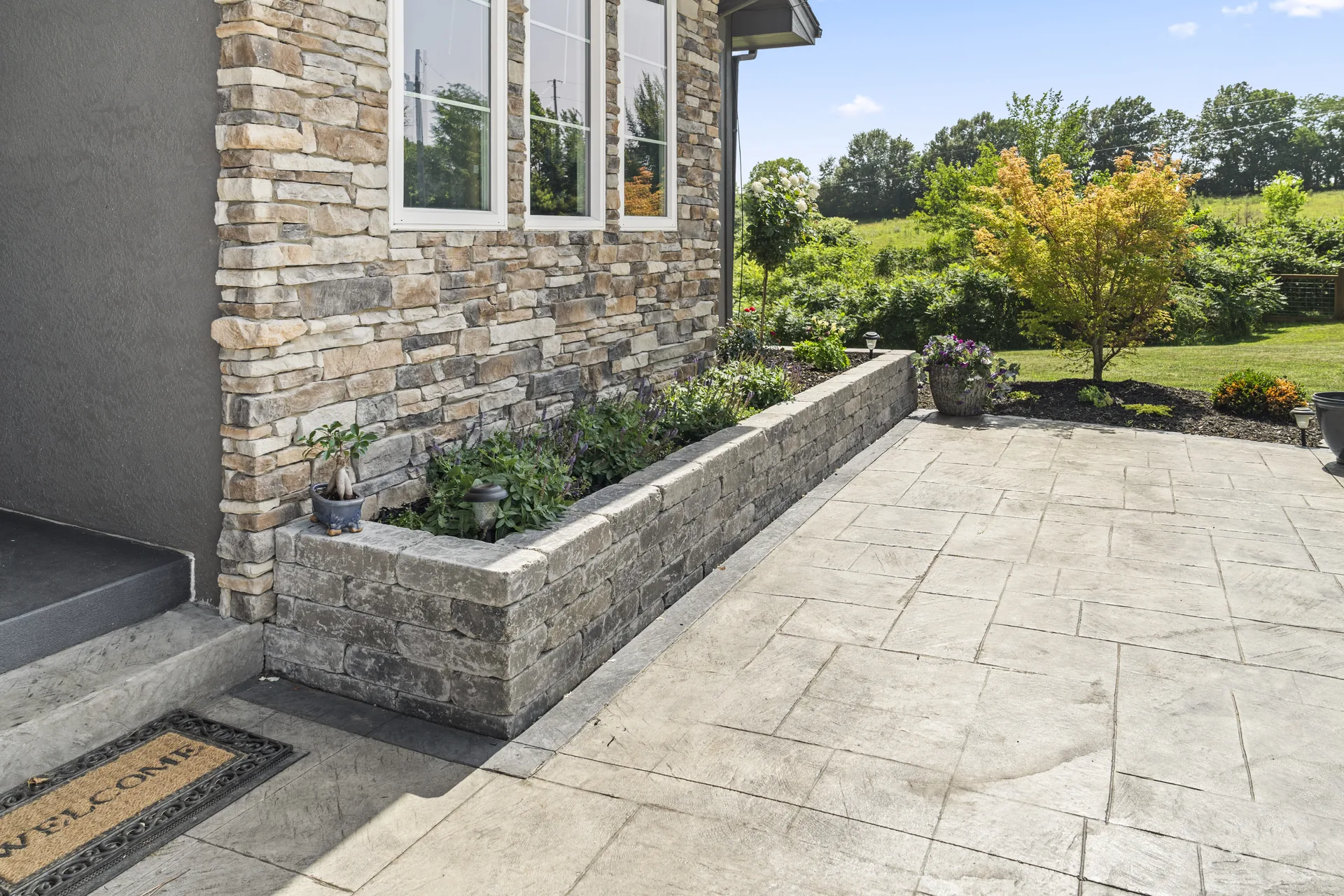 Stone planter and patterned walkway near the back door