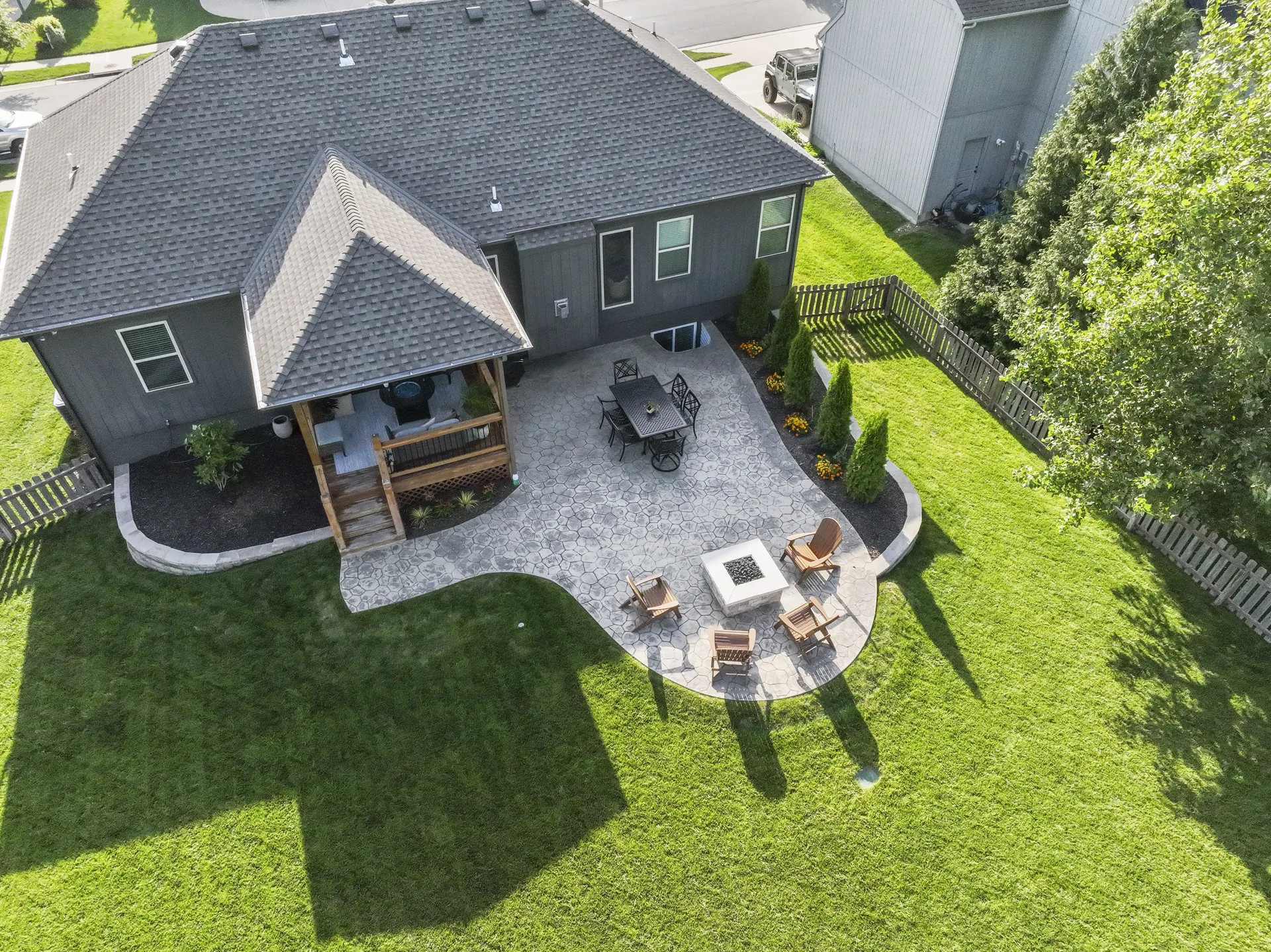 Angled aerial view of the patio, dining area and square fire pit