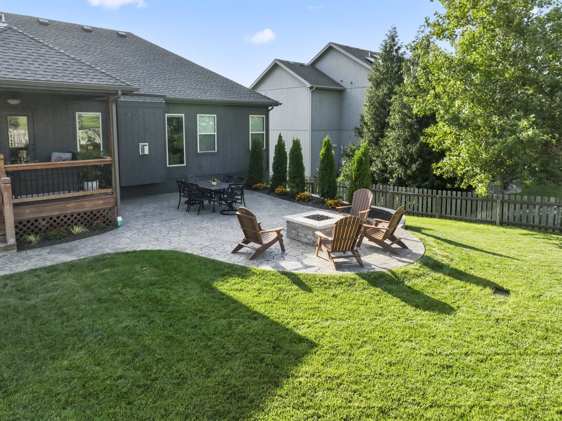 Patio seating and planting beds viewed from across the lawn