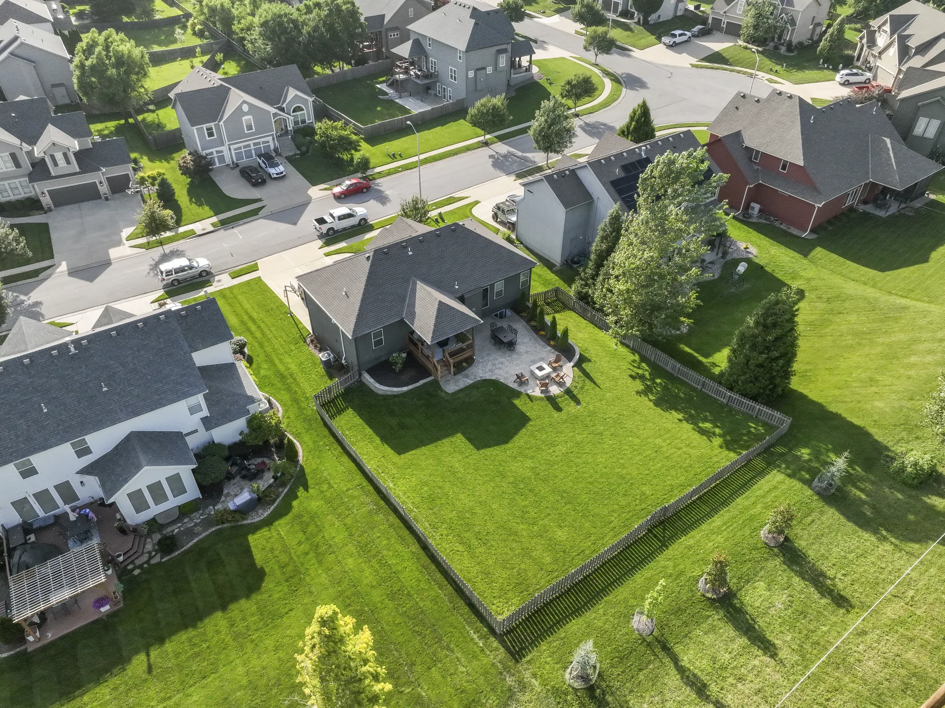 Wide aerial view of the home, fenced yard and patio layout