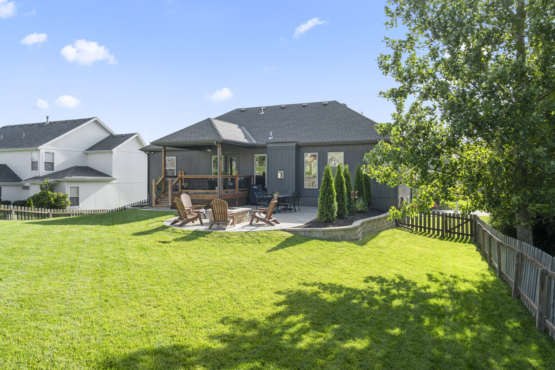 Full backyard view of the covered deck and paver seating area