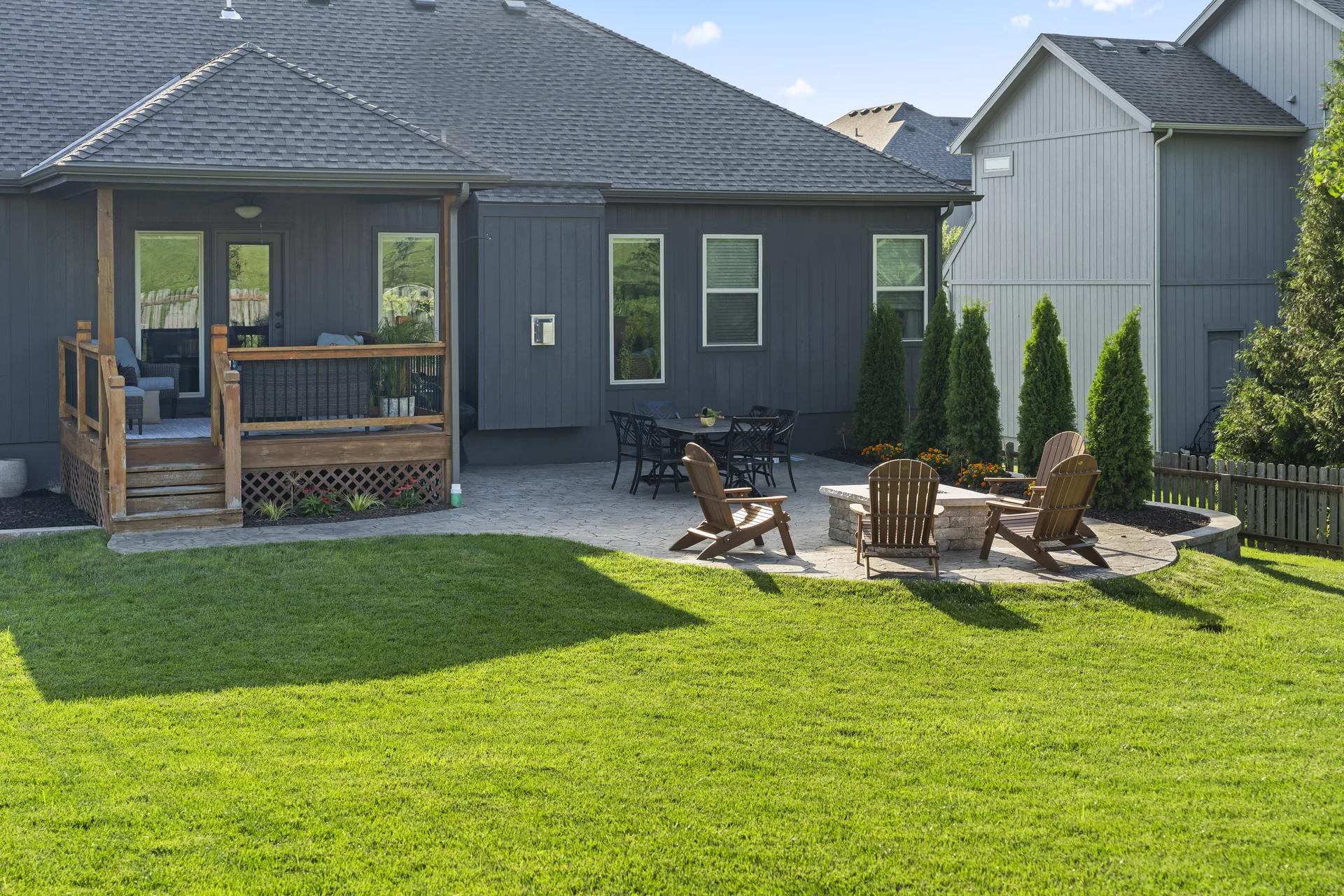 Covered deck and paver patio with dining and fire-pit seating
