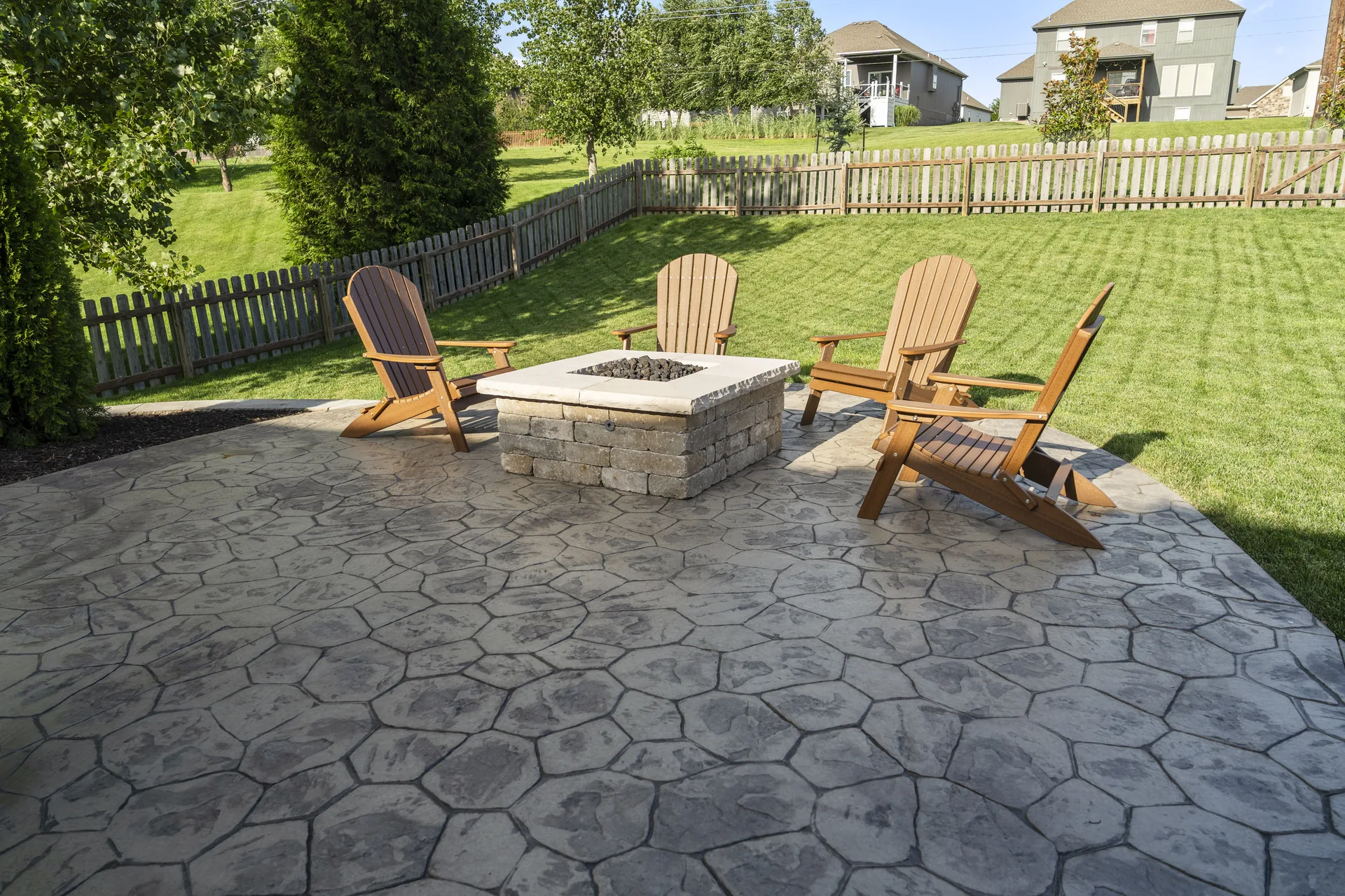 Fire pit and patio chairs with lawn behind