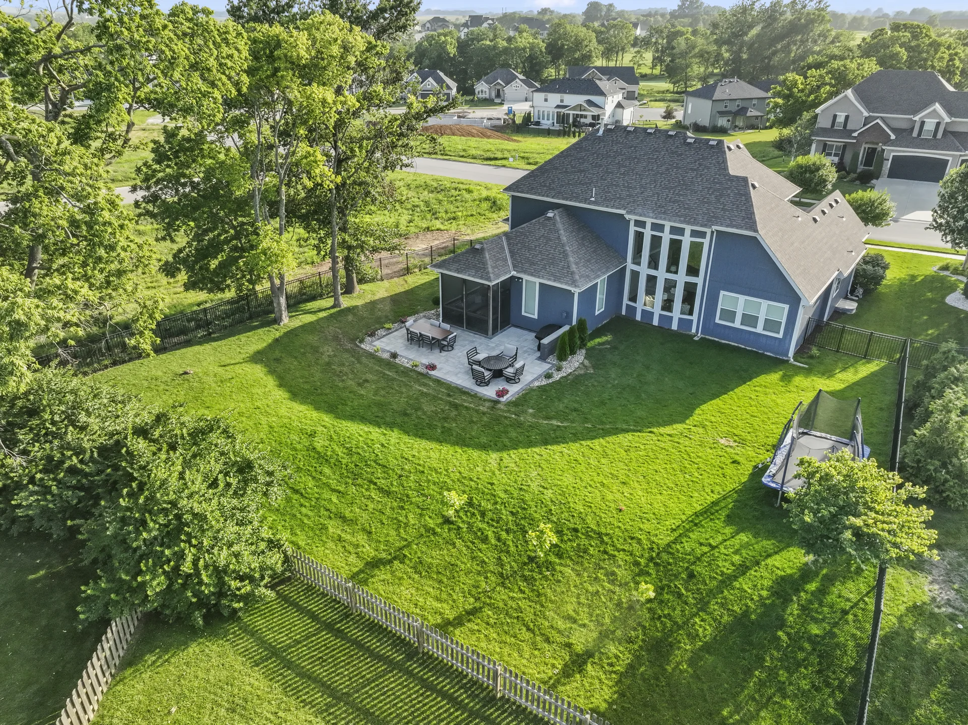 Wide aerial view of the home, patio and trees