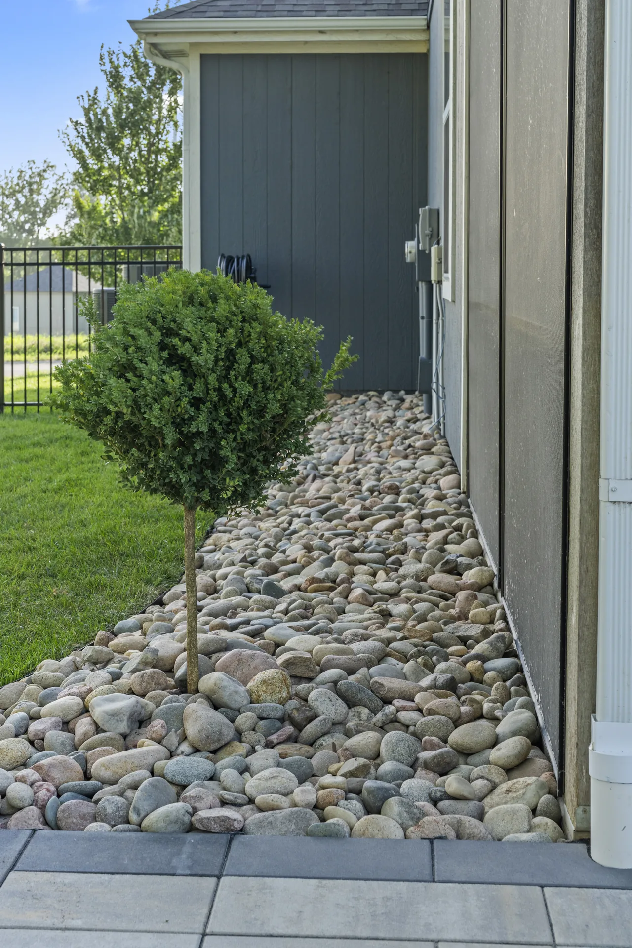Stone ground cover and planting along the house