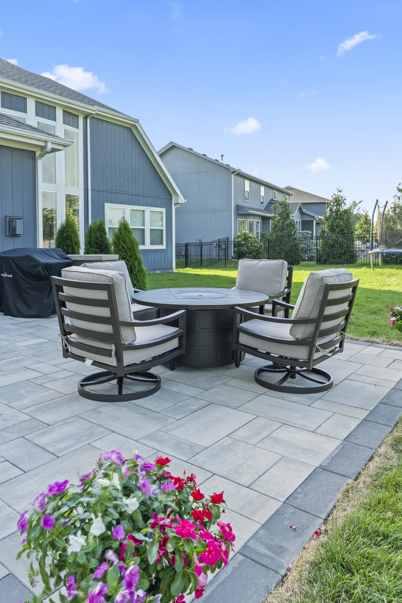 Patio seating and flowering planters viewed from the lawn