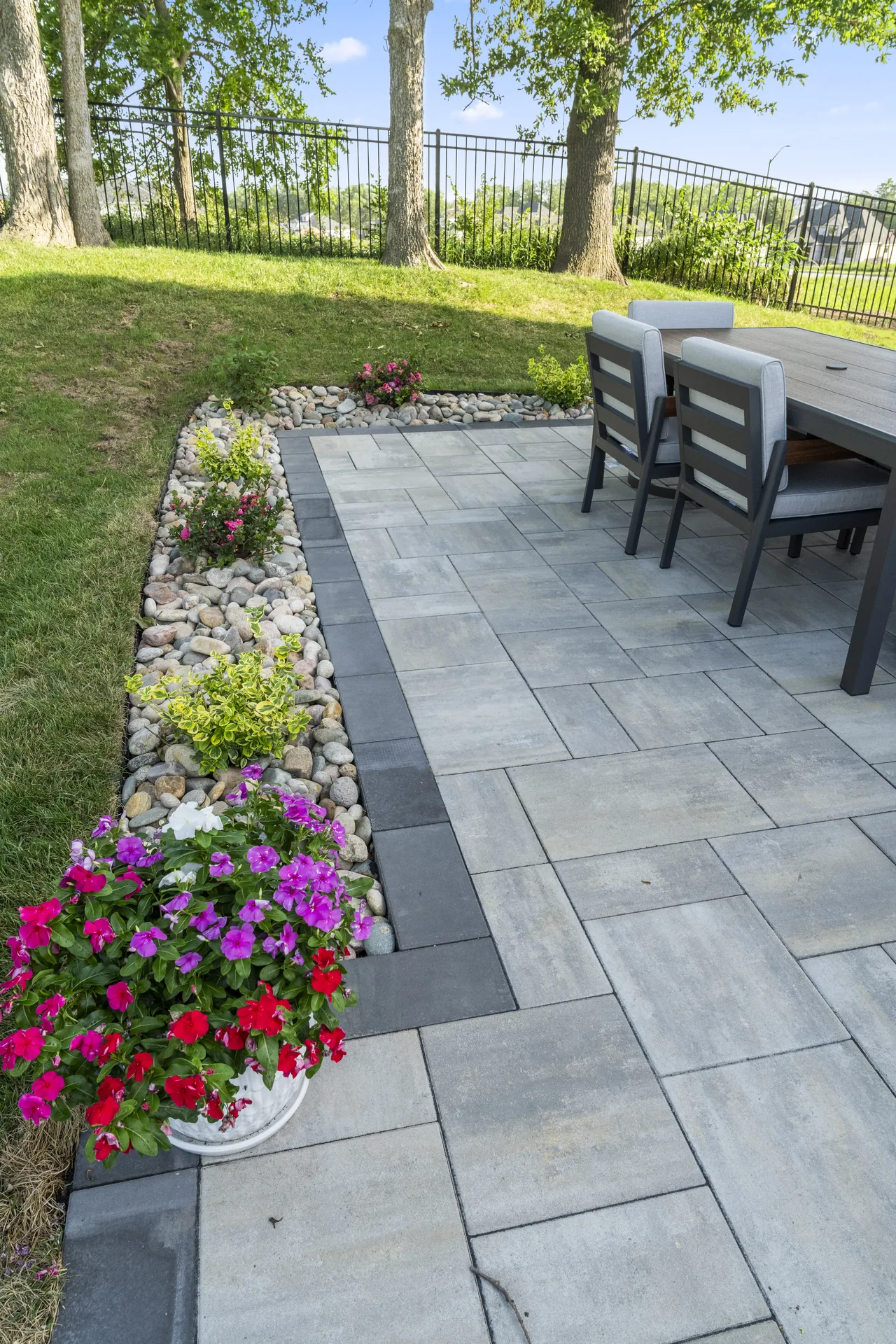 Dining table beside flowers and large-format pavers
