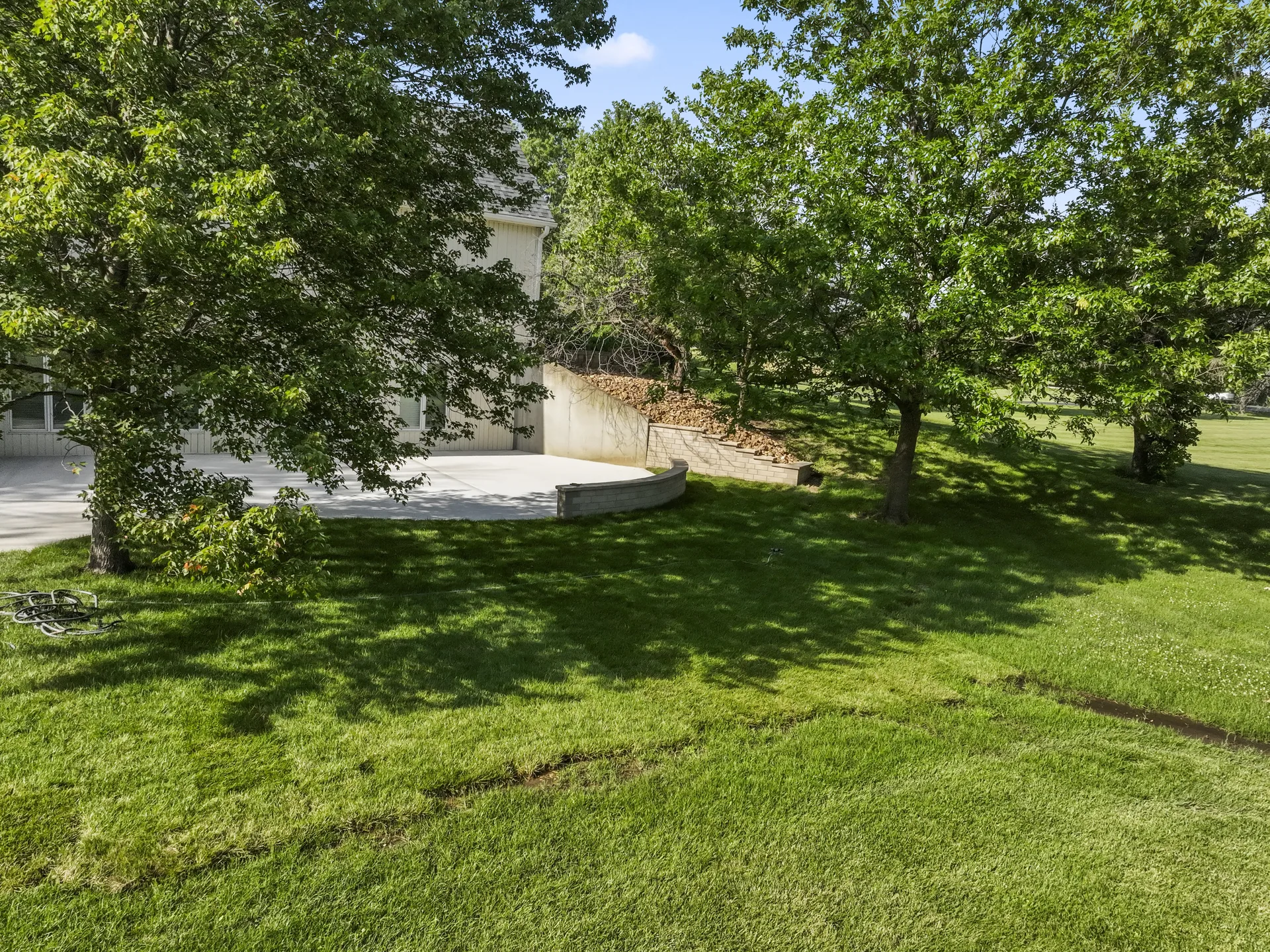 Wide view of the sloping lawn above the concrete patio