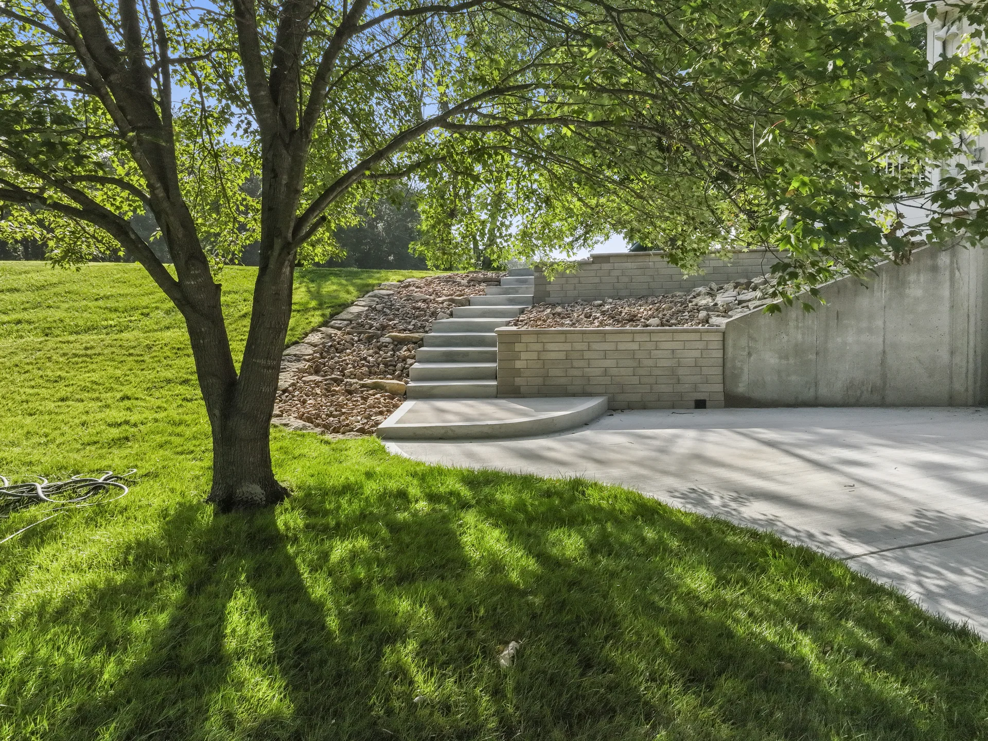 Retaining wall bordering the paved area beneath trees