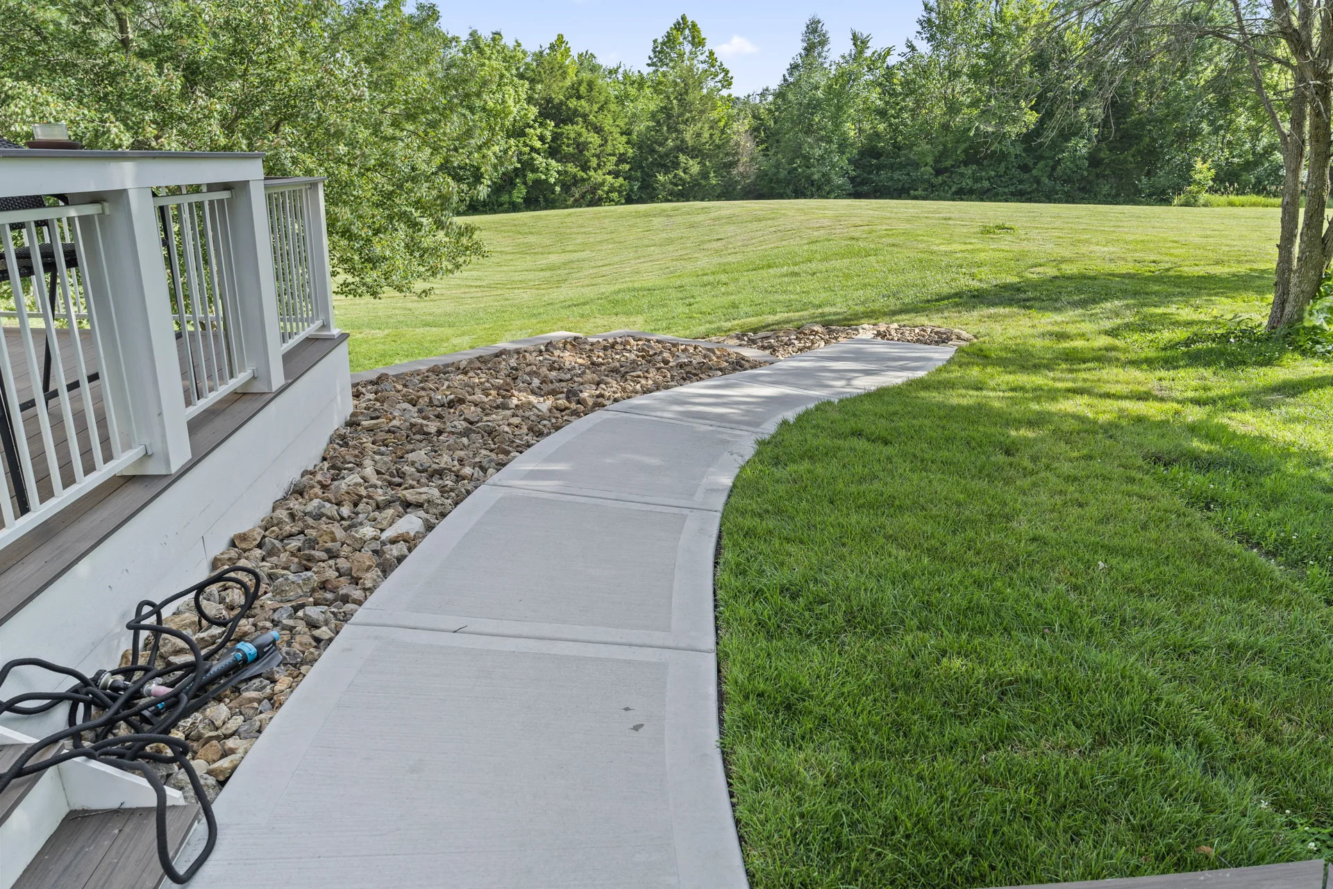 Curved concrete walkway leading around the home