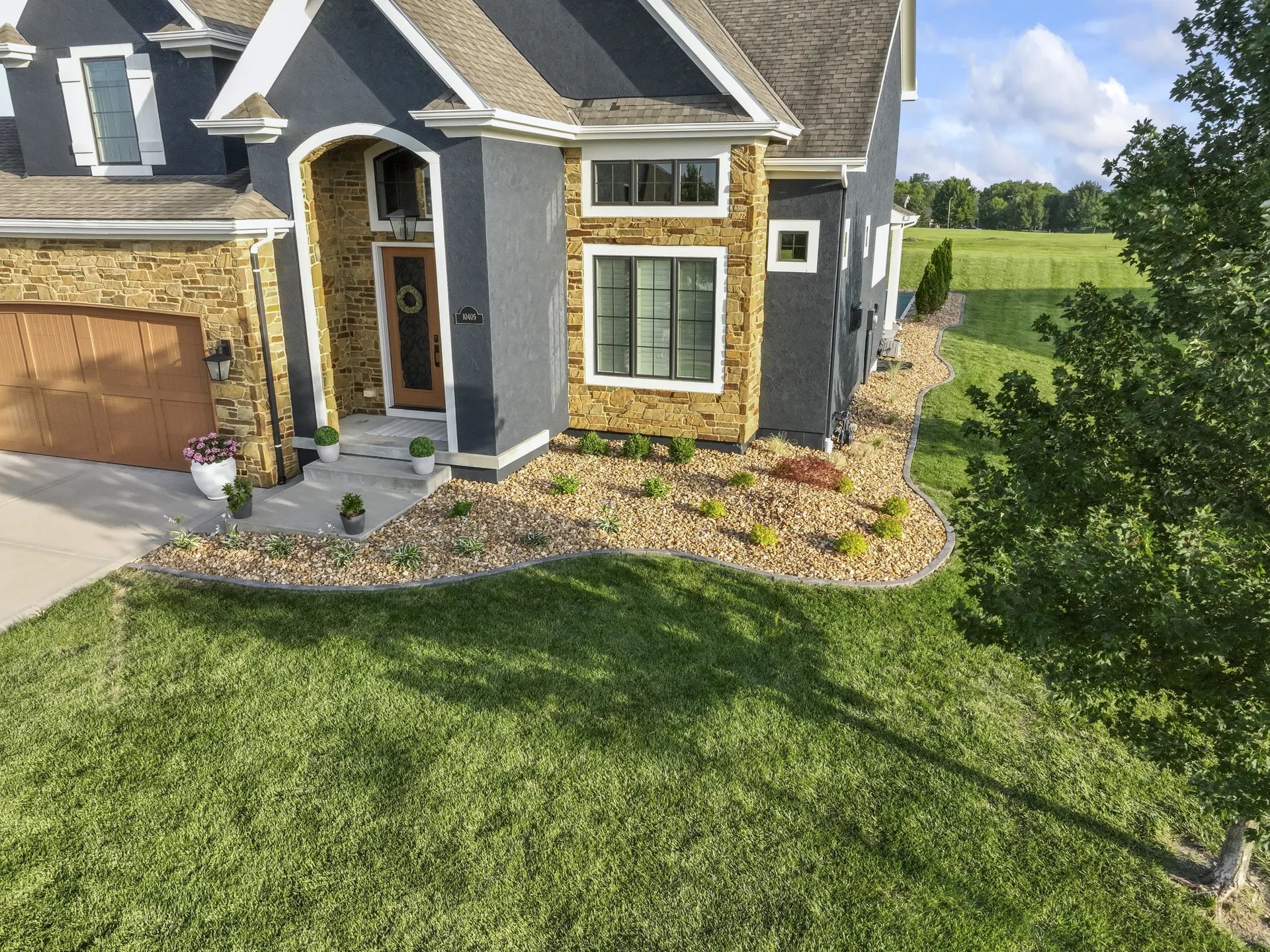 Front walk bordered by stone and flowering plants