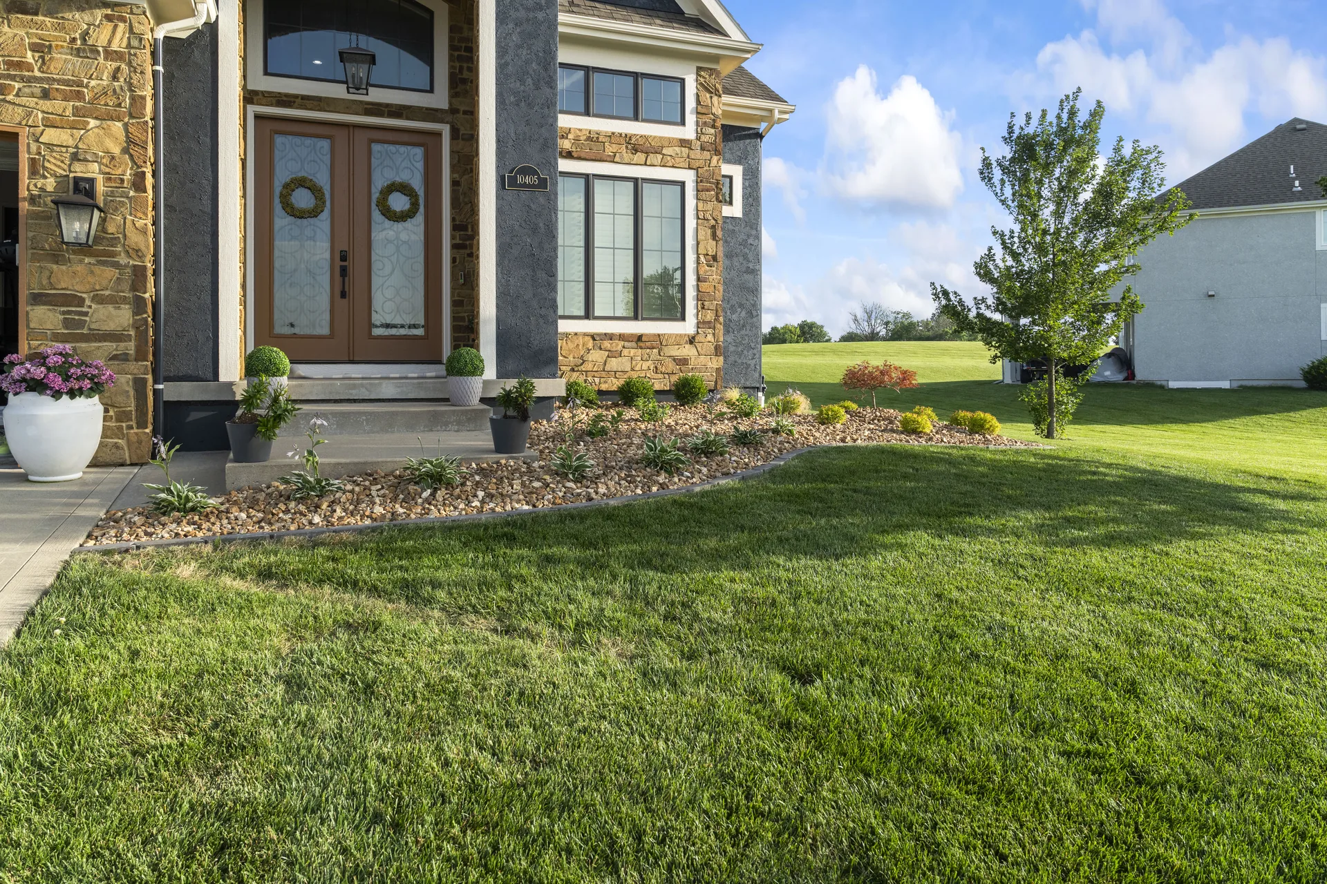Curved stone-edged bed beside the front entrance