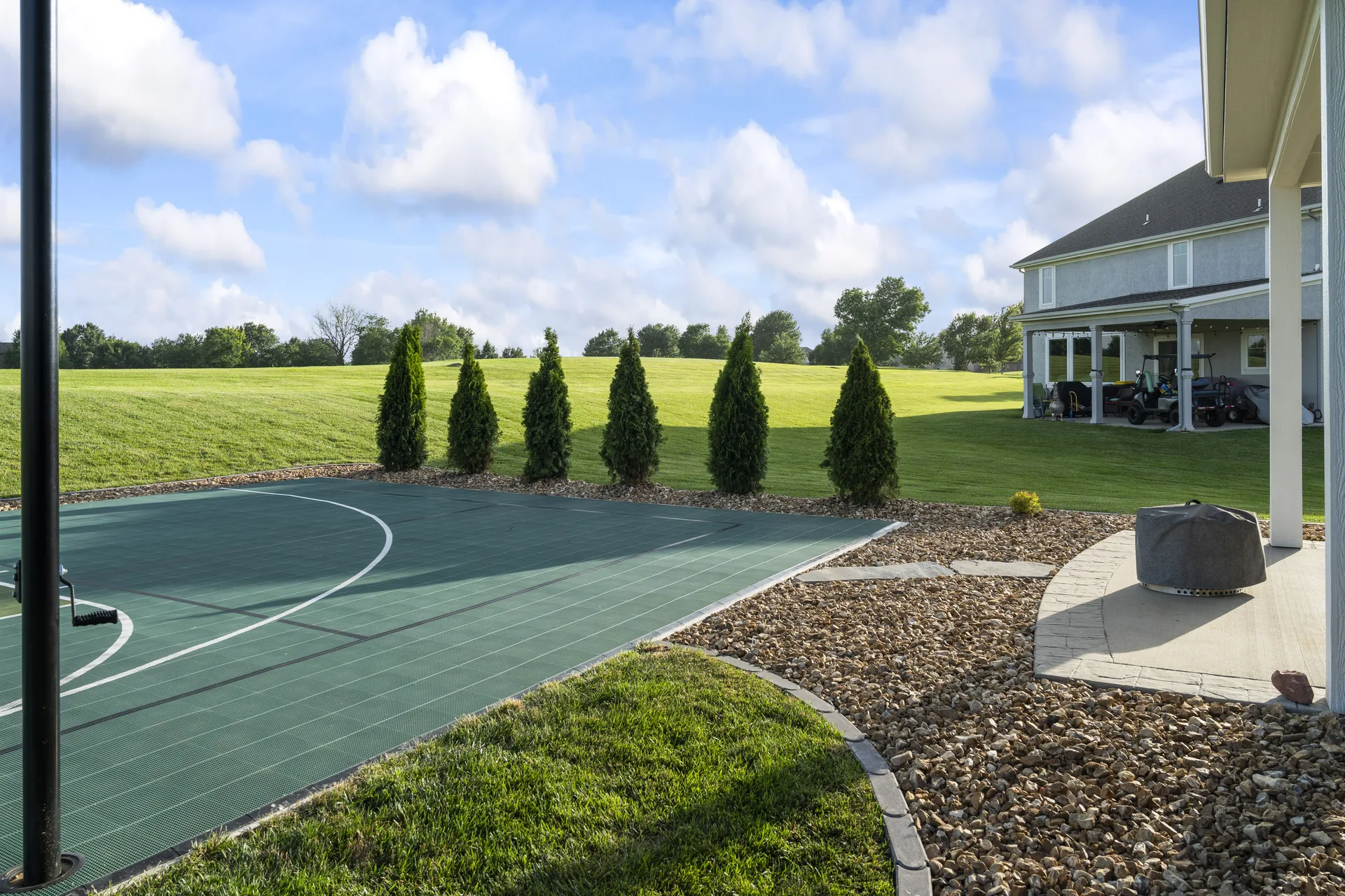 Basketball hoop framed by the yard and planting beds