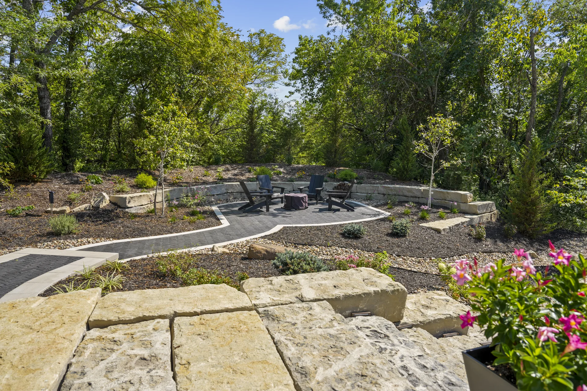 Paver paths framed by stone and planting beds