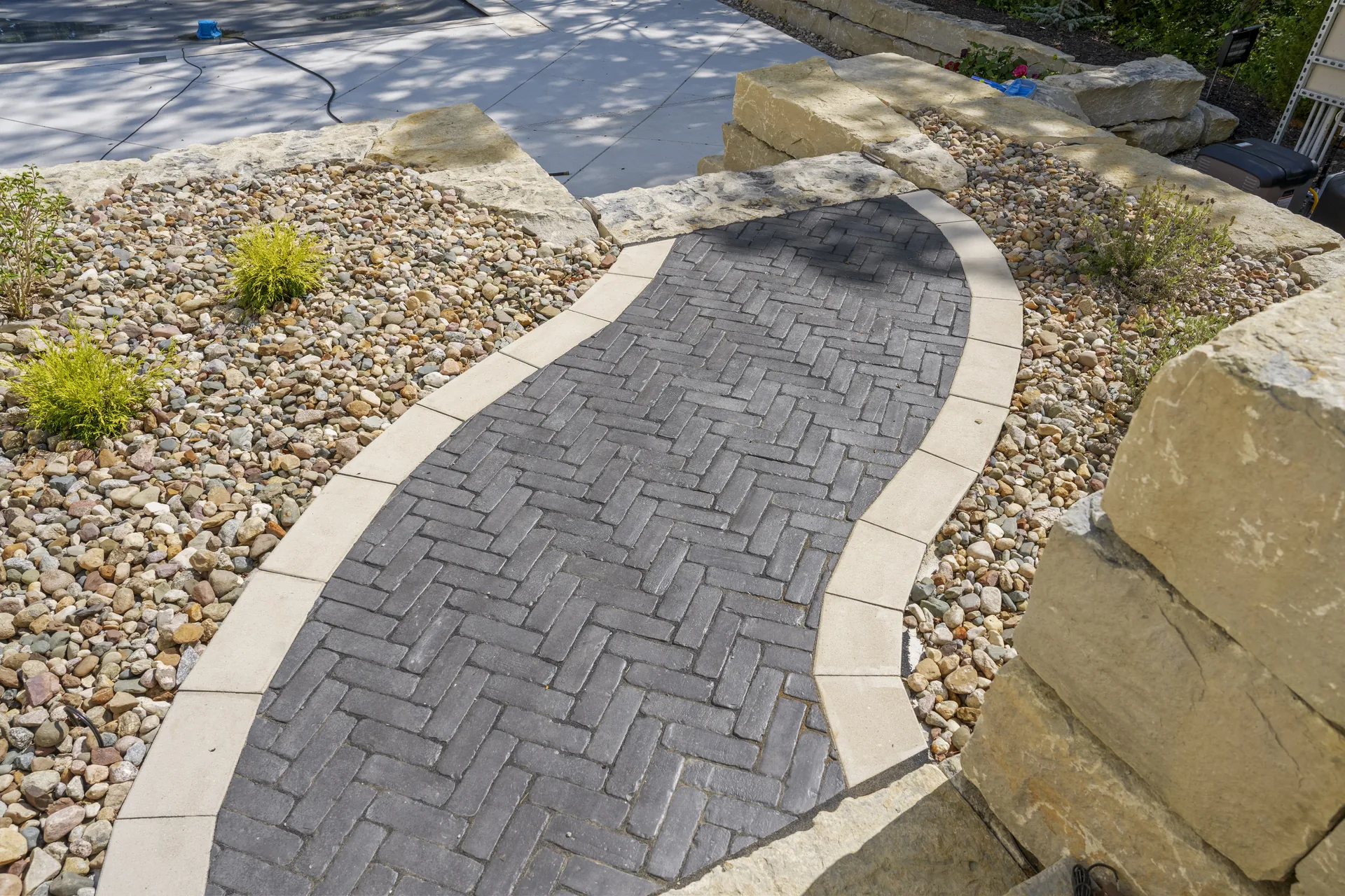 Paver walk running past a raised stone bed