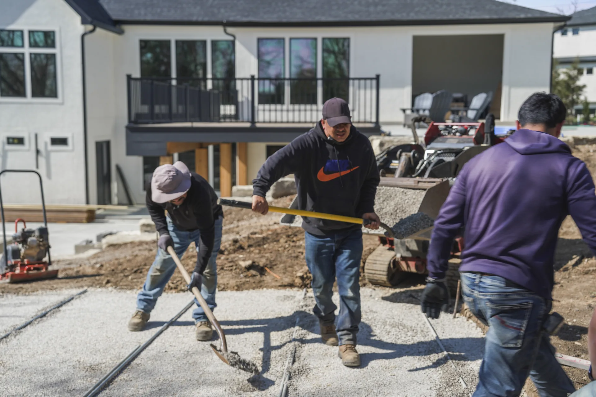 Crew working along the edge of a new paver surface
