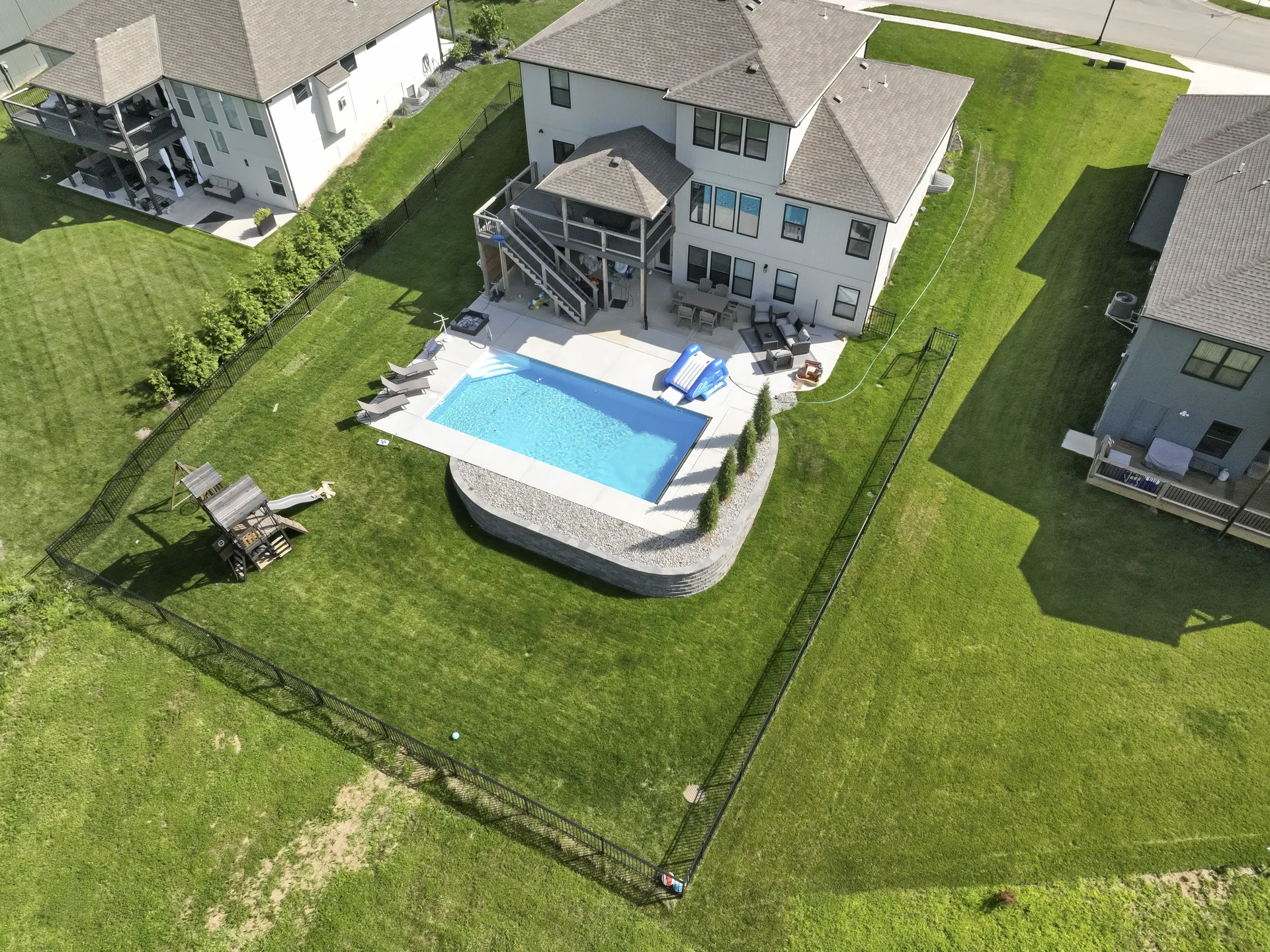 Angled aerial view of the pool, lawn and deck