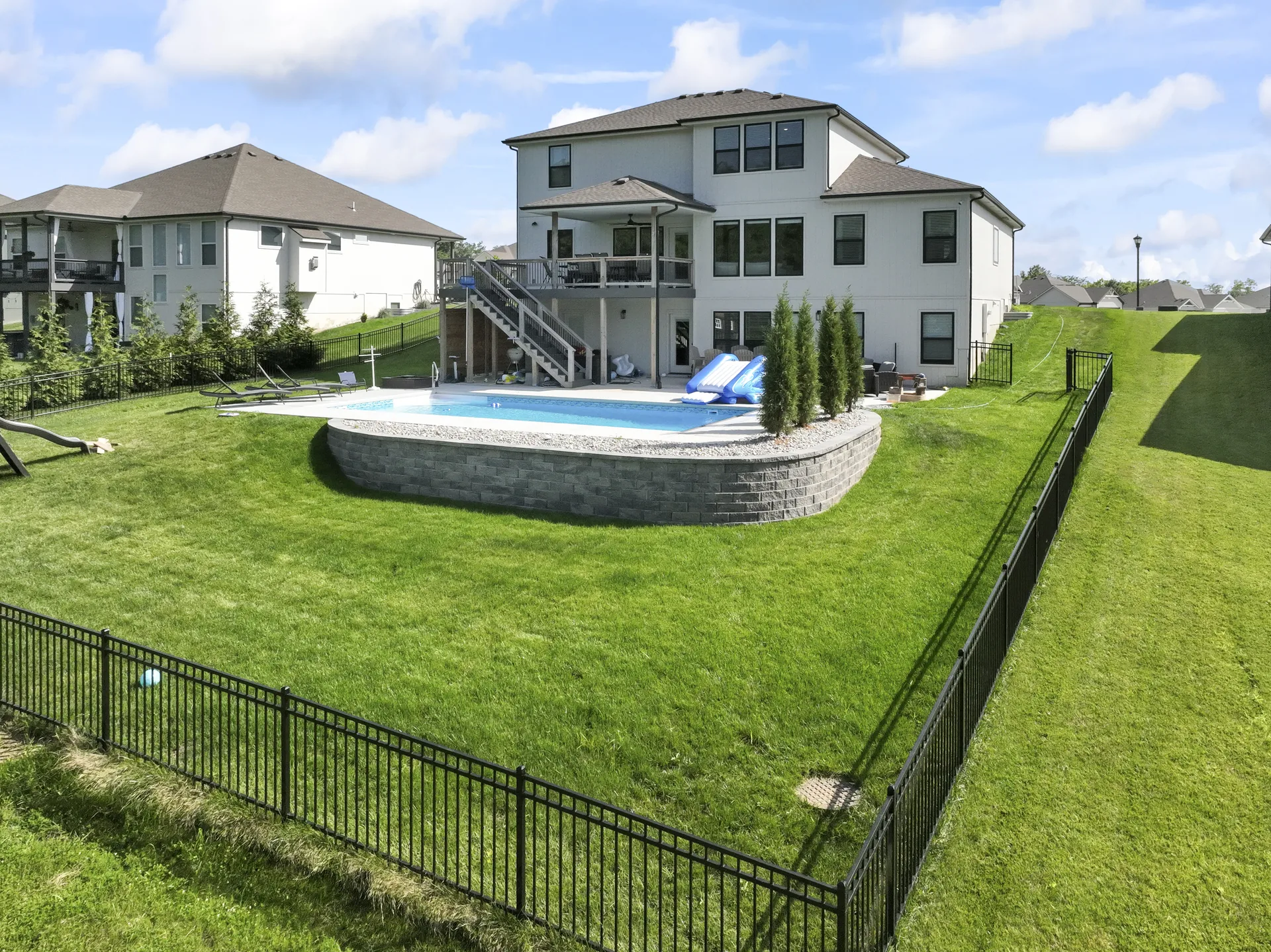 Backyard perspective on the curved wall and pool