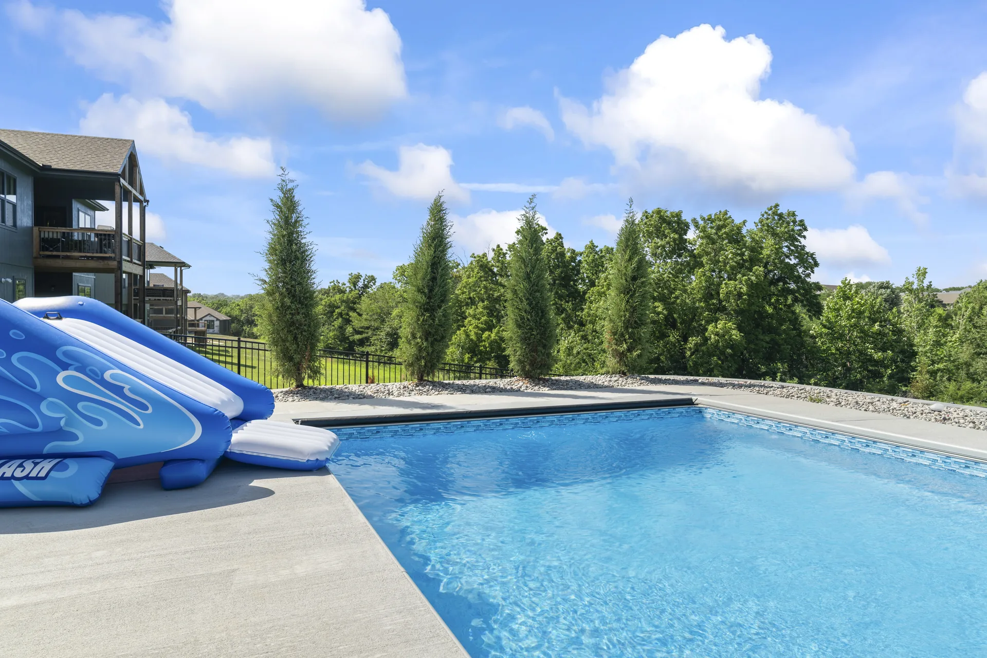 Poolside view with a line of evergreens