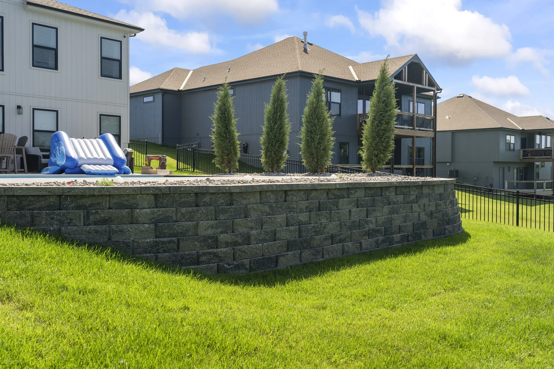 Block wall and evergreens along the pool edge